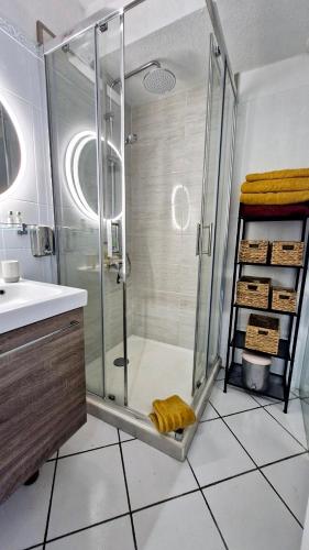 une salle de bain avec une douche avec une porte vitrée dans l'établissement Le Chrystina - T2 au port avec terrasse vue mer - Parking WIFI clim, à Saint Cyprien Plage