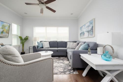 a living room with a blue couch and a table at Be A Nomad - Combined Home for Groups II - Steps to Ocean in Jacksonville Beach