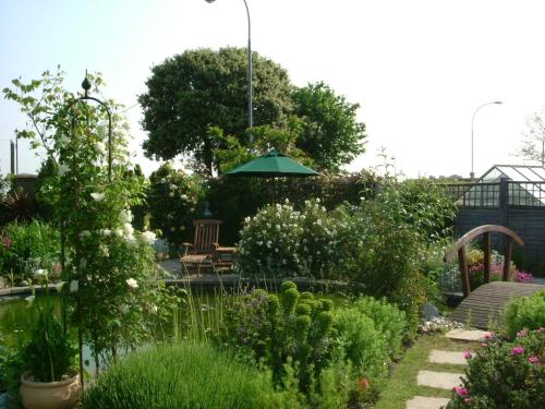 un jardín con mesa y sombrilla en Sea view flat at Claverton House, en Ryde
