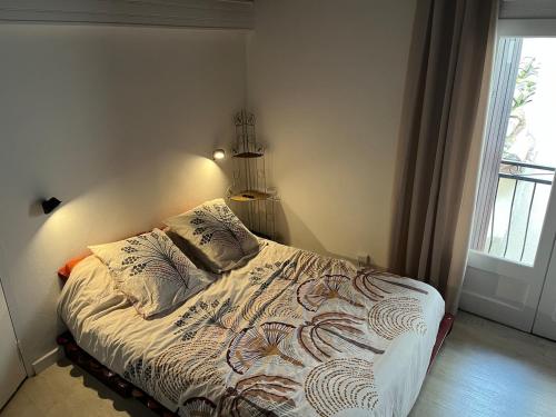 une chambre avec un lit dans une pièce avec une fenêtre dans l'établissement Saint-Gilles Appartement, à Saint-Gilles