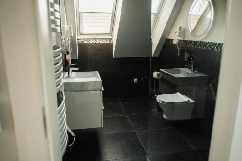 a bathroom with a sink and a toilet and a mirror at Szklany Przystanek in Kościerzyna