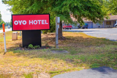 a red hotel sign sitting in the grass at OYO Inn Kernersville in Kernersville