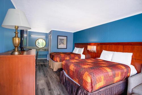 a hotel room with two beds and blue walls at OYO Inn Kernersville in Kernersville