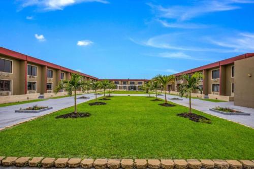 an empty courtyard with palm trees in front of a building at OYO Hotel Orlando Airport in Orlando