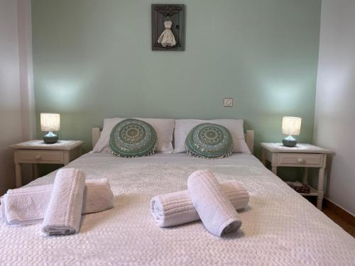 a bed with two pillows on it with two tables at SA nest in Spetses