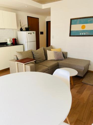 a living room with a couch and a kitchen at Depto Genova, Zona Norte, cochera con Reserva previa in Rosario
