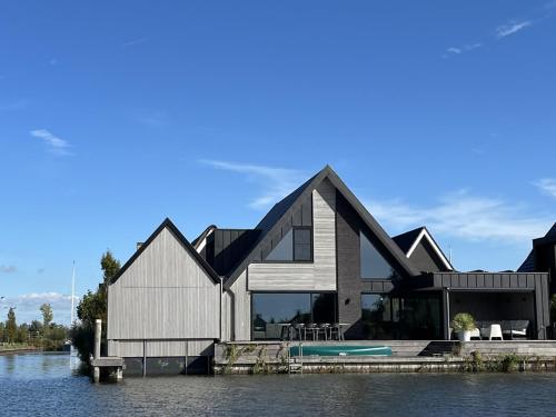a house on a body of water at Villa Lands End Stavoren in Stavoren