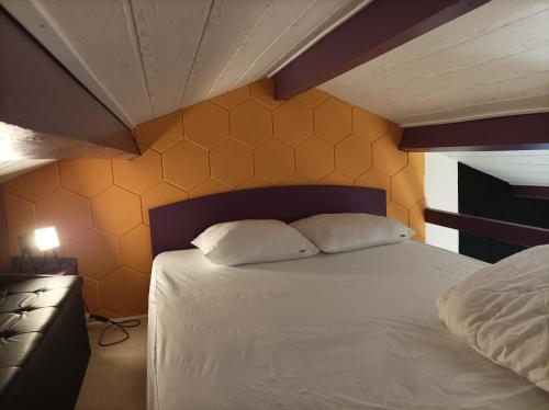 une chambre avec un lit avec deux oreillers dessus dans l'établissement Gîte Pop Rock - La Note bleue, à Sainte-Radégonde-des-Noyers