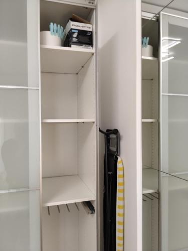 a closet with white shelves and a umbrella at Odysea in Comiso