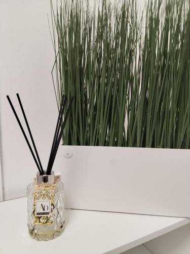 a vase with sticks in it next to some grass at Odysea in Comiso