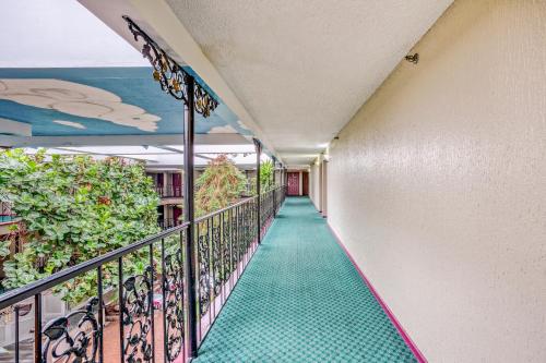 a corridor of a building with a green floor at OYO Townhouse Tulsa Woodland Hills in Tulsa