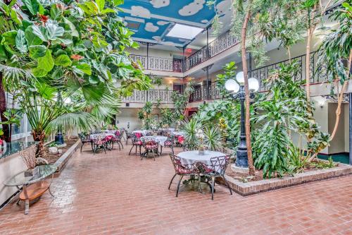 a room with tables and chairs and plants at OYO Townhouse Tulsa Woodland Hills in Tulsa