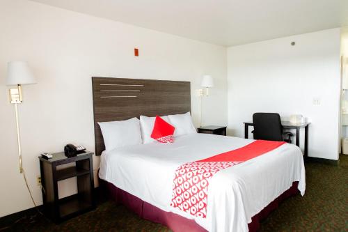 a hotel room with a large bed with red pillows at OYO Hotel Wichita Falls I-44 Sheppard Airforce in Wichita Falls