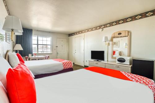 a hotel room with two beds and a television at OYO Hotel Wichita Falls I-44 Sheppard Airforce in Wichita Falls