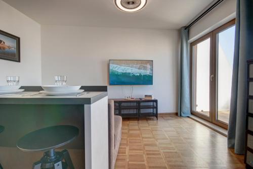 een woonkamer met een aanrecht en een tafel bij HelApart - Helska Villa in Hel