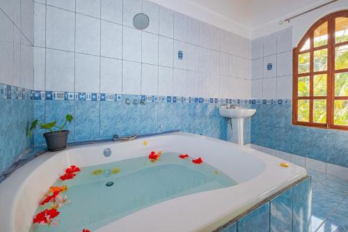 a bathroom with a bath tub with flowers in it at Relax in Paradise - Villa Infiniti in Talamanca