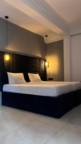 a large bed in a room with two lights at Urban Alley Kandy in Kandy