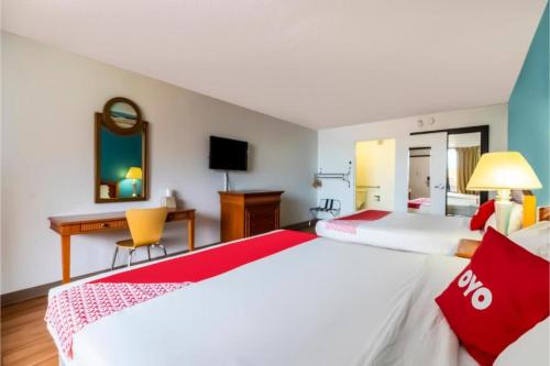 a hotel room with two beds and a desk at OYO Hotel Bossier City LA - Red River in Bossier City