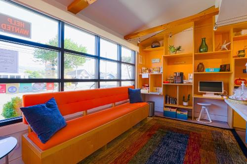 an orange couch in a room with a large window at Coast River Inn by OYO Seaside in Seaside