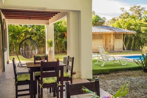 a patio with a table and chairs and a pool at Relax in Paradise - Villa Infiniti in Talamanca