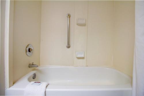 a white bath tub in a bathroom with a shower at Tulsa Square Hotel Central, I-44 By OYO in Tulsa