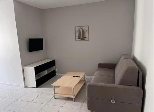 un salon avec un canapé et une table dans l'établissement Joli appartement sur Place de la Mairie, à Sète