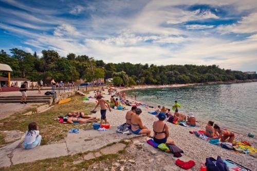 a group of people sitting on a beach at HI Hostel Pula in Pula