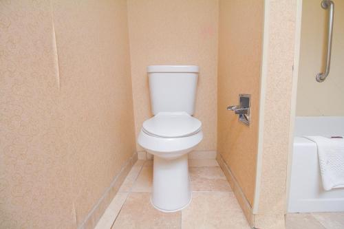 a bathroom with a toilet and a bath tub at Tulsa Square Hotel Central, I-44 By OYO in Tulsa