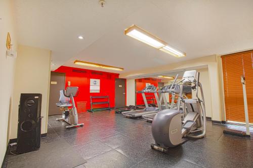 a gym with cardio equipment in a room with red walls at Tulsa Square Hotel Central, I-44 By OYO in Tulsa