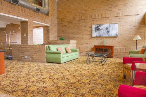 a living room with two couches and a brick wall at Tulsa Square Hotel Central, I-44 By OYO in Tulsa