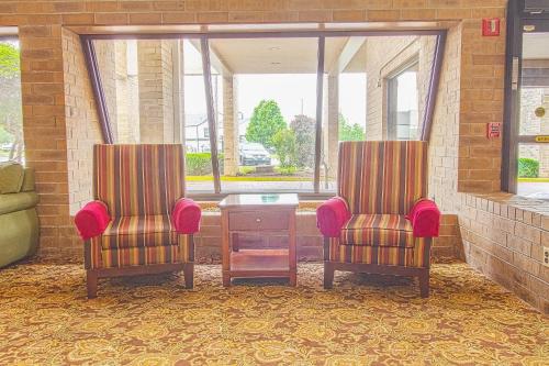 two chairs and a table in a room at Tulsa Square Hotel Central, I-44 By OYO in Tulsa