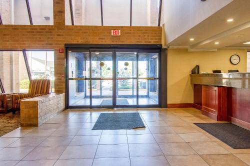 an empty lobby with a large glass door in a building at Tulsa Square Hotel Central, I-44 By OYO in Tulsa