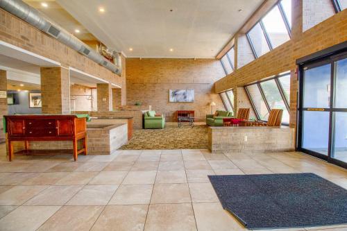 a large room with a piano and a living room at Tulsa Square Hotel Central, I-44 By OYO in Tulsa