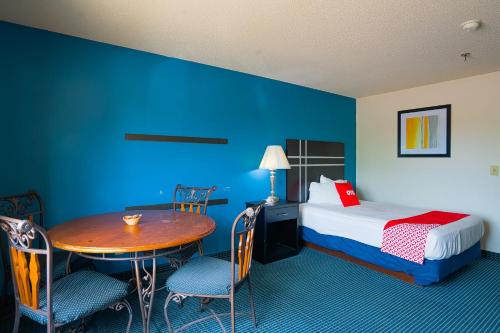 a hotel room with a bed and a table and chairs at OYO Hotel Redwood Falls near Jackpot Casino in Redwood Falls