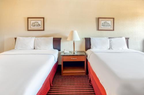 a hotel room with two beds and a table with a lamp at OYO Hotel Jefferson TX Hwy 59 in Jefferson
