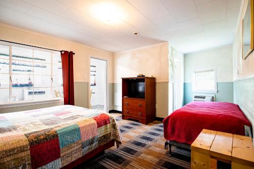 a bedroom with a bed and a flat screen tv at Lloyd's On The River Country Inn By Oyo in Bryson City
