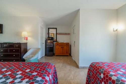 a bedroom with a bed and a dresser and a kitchen at Pelican Inn by Belvilla Aransas Pass, TX in Aransas Pass