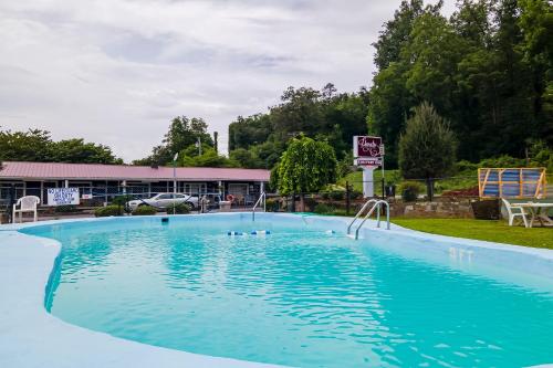 a large swimming pool in front of a building at Lloyd's On The River Country Inn By Oyo in Bryson City