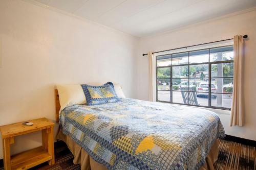 a bedroom with a bed and a window at Lloyd's On The River Country Inn By Oyo in Bryson City