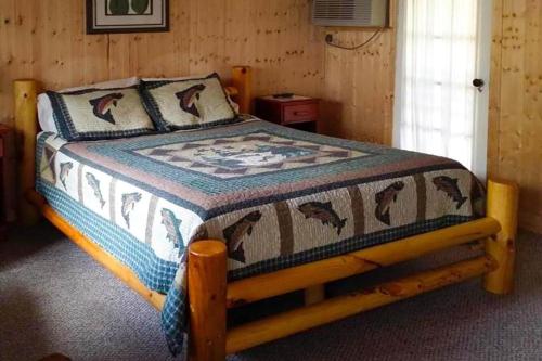 a bedroom with a bed with a quilt on it at Lloyd's On The River Country Inn By Oyo in Bryson City