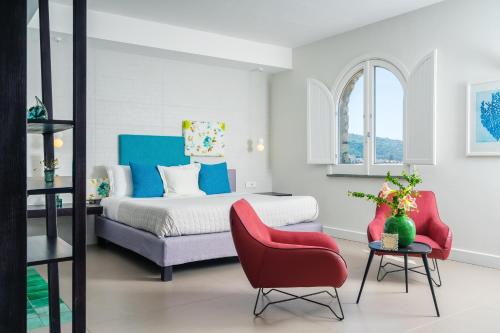 a bedroom with a bed and a red chair at Villa Ketty Resort in Vico Equense