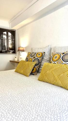 - une chambre avec un lit doté d'oreillers jaunes et noirs dans l'établissement Appartements de caractère - Cœur de ville, à Pont-Audemer