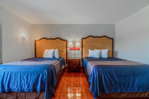 a hotel room with two beds with blue sheets at Pelican Inn by Belvilla Aransas Pass, TX in Aransas Pass