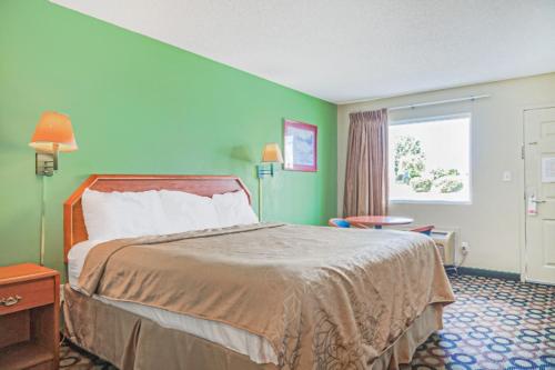 a hotel room with a bed and a window at Economy Inn By OYO Ashburn in Ashburn