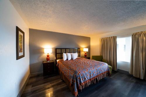 a hotel room with a bed and a window at OYO Hotel Ocala, FL I-75 in Ocala