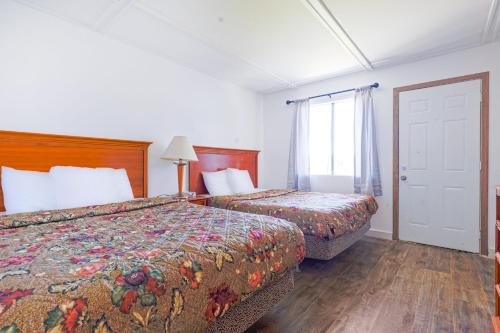 a hotel room with two beds and a window at Country Hearth Inn & Suites By OYO Sturgis in Sturgis
