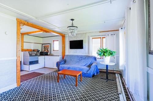 a living room with a blue chair and a table at Country Hearth Inn & Suites By OYO Sturgis in Sturgis