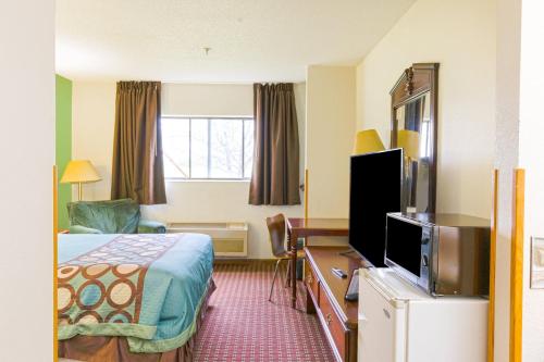 a hotel room with a bed and a flat screen tv at Super Sleep Inn in Princeton