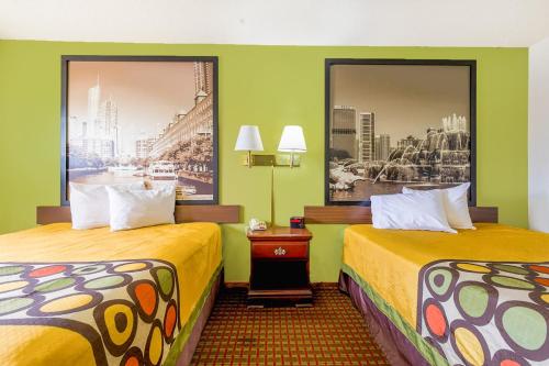 two beds in a hotel room with green walls at Super Sleep Inn in Princeton