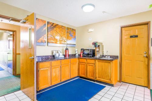 a kitchen with wooden cabinets and a blue floor at Super Sleep Inn in Princeton